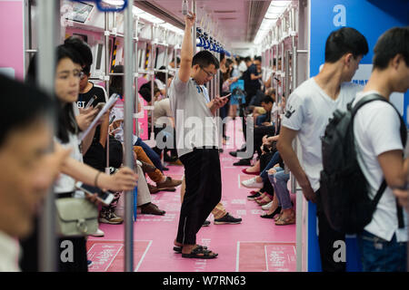 Chinese commuters are pictured in a subway train featuring pink decorations to encourage people to declare their feelings in Shenzhen city, south Chin Stock Photo