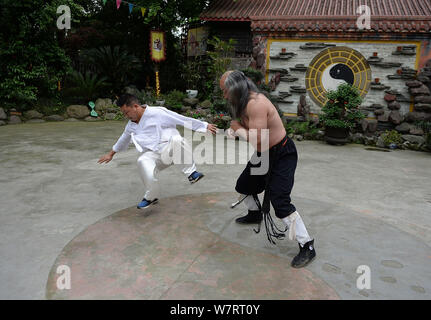 He Daojun, right, the master of Chengdu Qingcheng Kungfu, performs kungfu and martial arts with his disciple at Mount Qingcheng in Dujiangyan city, so Stock Photo