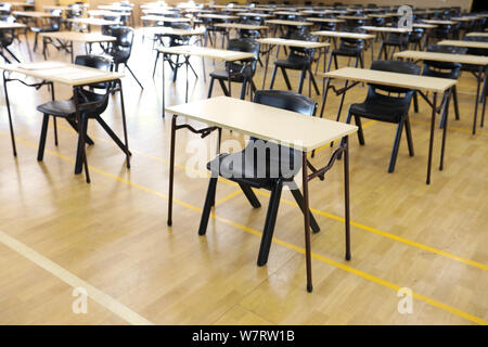 various views of an exam examination room or hall set up ready for students to sit test. multiple desks tables and chairs. Education, school, student Stock Photo