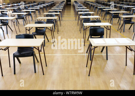 interior inside of an exam examination room or hall set up ready for students to sit test. multiple desks tables and chairs. Education, school, studen Stock Photo