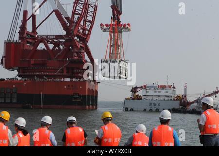 Workers install the final piece of the 5,664-meter-long undersea tunnel of the Hong Kong-Zhuhai-Macao Bridge under construction in Zhuhai city, south Stock Photo