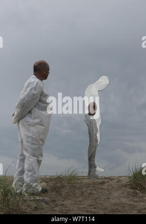 Man (assistant to the artist) looking into giant mirror in the shape of a person, a public sculpture by Rob Mullholland, Port Saint Louis du Rhone, Camargue, France, May 2013. Editorial Use only. Credit Jean Roche / Le Citron Jaune / Mullholland Stock Photo