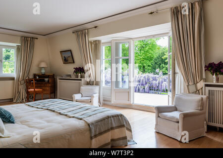 Open double doors in country style bedroom Stock Photo