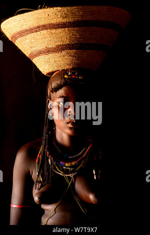 Portrait of Ovahakaona woman carrying basket on head, Ovahakaona people. Kaokoland, Namibia. Stock Photo