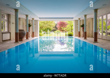 Modern interior design of indoor swimming pool with pool beds, night scene, hotel resort, spa 
