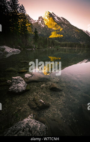 Amazing morning scenery on Hintersee Lake with alpine peaks reflected on the water during spring time Stock Photo