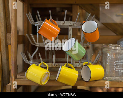 Yellow and Orange colors Empty Cups Hanging on a Little Iron Hanger. Stock Photo