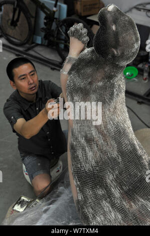 Xie Yong, Professor Xie Yong of Shenyang University, makes an otter sculpture made out of 300,000 sewing needles at his studio in Shenyang city, north Stock Photo