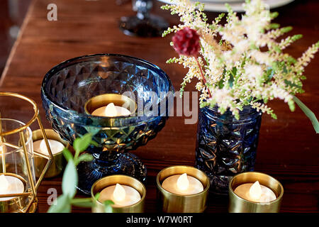 Decoration table newlyweds, blue dishes, bottles of flowers and candles.Wedding floristry. Stock Photo