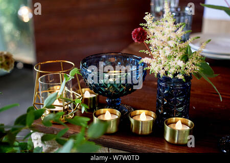 Decoration table newlyweds, blue dishes, bottles of flowers and candles.Wedding floristry. Stock Photo