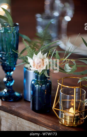 Decoration table newlyweds, blue dishes, bottles of flowers and candles.Wedding floristry. Stock Photo