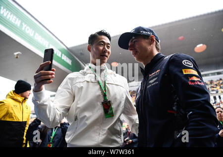 Dutch F1 driver Max Verstappen of Red Bull Racing, right, takes selfies with retired Chinese table tennis player Wang Liqin ahead of the 2017 Formula Stock Photo