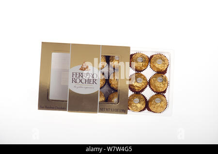 Ferrero Rocher fine hazelnut chocolates in gold foil with box Stock Photo