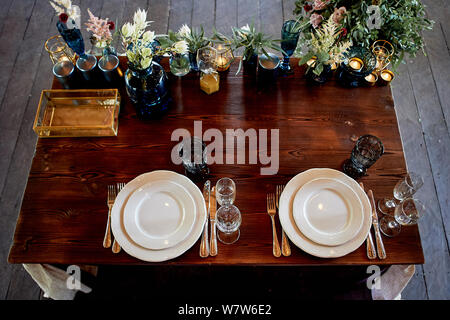 Decoration table newlyweds, blue dishes, bottles of flowers and candles.Wedding floristry. Stock Photo