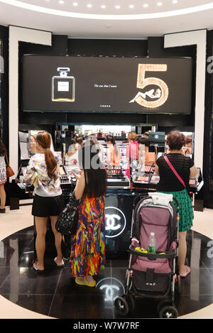--FILE--Customers shop at a boutique of Chanel in a duty-free shopping mall in Sanya city, south China's Hainan province, 30 November 2014.   Offshore Stock Photo