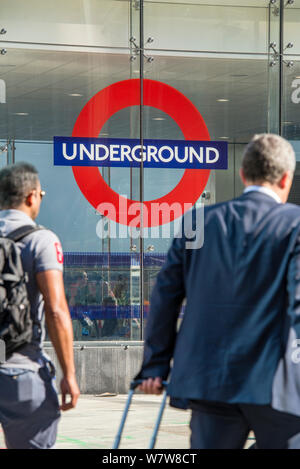 Two businessmen on their morning commute at the entrance to Victoria Underground Station, Central London. Stock Photo