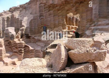 Chinese workers excavate the 600-year-old millstone pits spread out within a 7,000-square-meter area to obtain millstones used to grind rice and beans Stock Photo