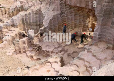 Chinese workers excavate the 600-year-old millstone pits spread out within a 7,000-square-meter area to obtain millstones used to grind rice and beans Stock Photo