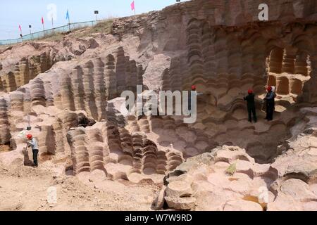 Chinese workers excavate the 600-year-old millstone pits spread out within a 7,000-square-meter area to obtain millstones used to grind rice and beans Stock Photo