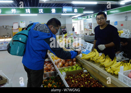 --FILE--A customer uses scans a QR code through Chinese online payment service Alipay of Alibaba's Ant Financial on his smartphone to pay for fruit he Stock Photo