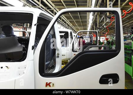 --FILE--A Chinese worker assembles trucks on the assembly line at an ...