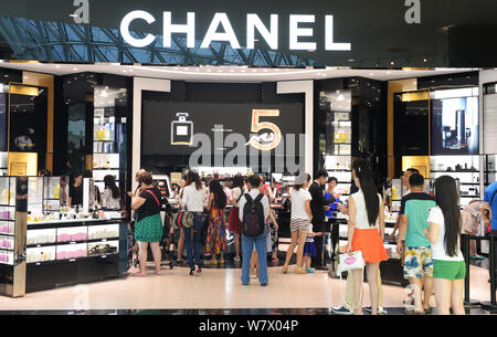--FILE--Customers shop at a boutique of Chanel in a duty-free shopping mall in Sanya city, south China's Hainan province, 30 November 2014.   Offshore Stock Photo