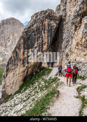 Trekkers enjoy rugged mountain scenery en-route to the Rotwand hut refuge in the Rosengarten area of the Italian Dolomites the Alto Adige Stock Photo
