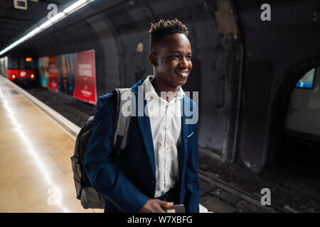 African American businessman wearing blue suit and backpack Stock Photo