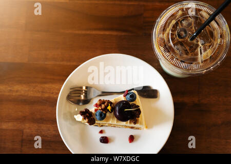 Piece of carrot fruit cake and ice coffee on coffee cafe, close up top view Stock Photo