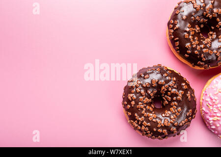 Colorful donuts on rose background Stock Photo