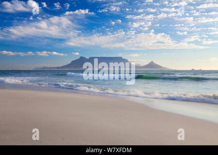 Wave washing over beach at dusk with table mountain beyond. Bloubergstrand, Cape Town, South Africa. October 2011. Non-ex. Stock Photo