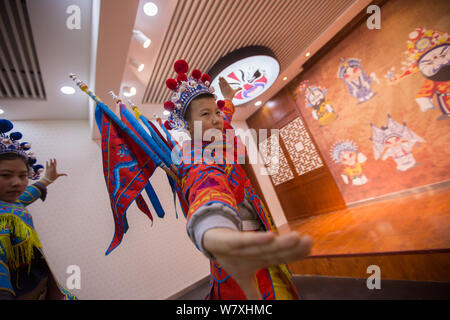 A pupil from Jilin Primary School dressed in elaborate Peking Opera costume and headwear takes an opera class in Changchun city, northeast China's Jil Stock Photo