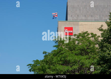 Montreal, Canada - August 6, 2019: La Presse newspaper sign on headquarter building exterior wall. Landscape format with blue sky, foliage and flags. Stock Photo