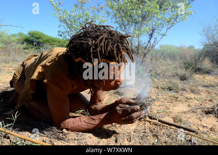 Naro San Bushman making fire in traditional manner, Kalahari, Ghanzi region, Botswana, Africa. Dry season, October 2014. Stock Photo