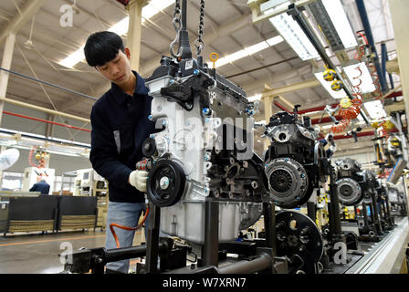 --FILE--A Chinese worker assembles an engine on the assembly line at an ...