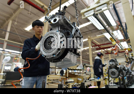 --FILE--A Chinese worker assembles an engine on the assembly line at an ...