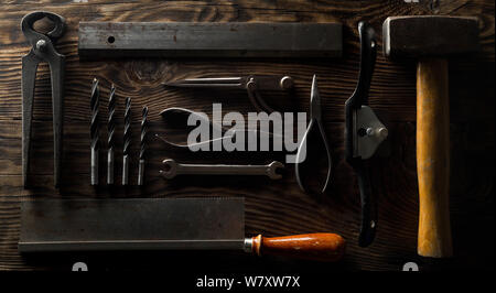 Collection of old, used wood working tools flat lay from above on dark moody wooden background - repair, craftsmanship or workshop concept Stock Photo