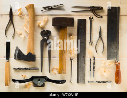 Collection of old, used wood working tools flat lay from above on light wooden background - repair, craftsmanship or workshop concept Stock Photo