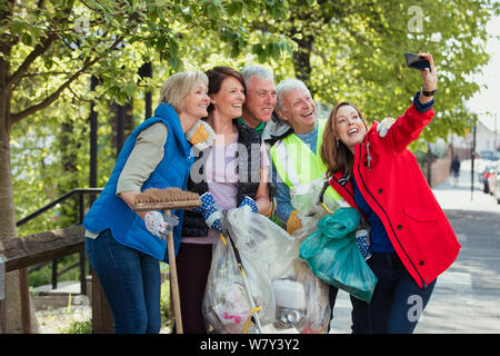A group of five people who are participating in a city clean-up taking a selfie. Stock Photo
