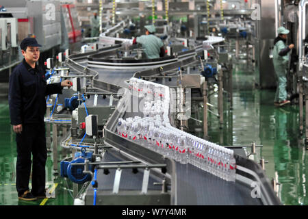 --FILE--A Chinese worker checks bottles of Wahaha purified water on the ...