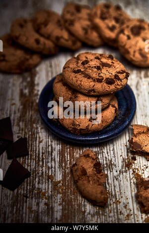 group of tasty cookies next to a bowl on an old wooden board Stock Photo