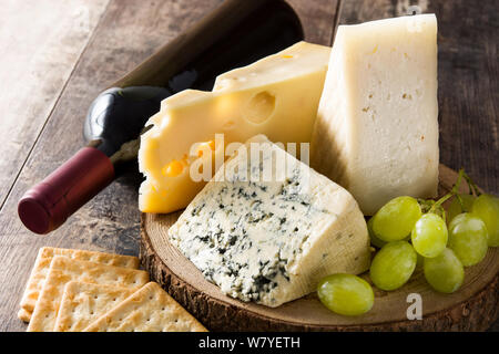 Assortment of cheeses and wine on wooden table. Close up Stock Photo