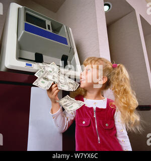 Child getting money from ATM Stock Photo