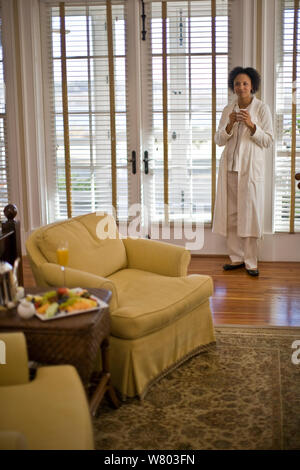 Woman standing in living room ready to eat breakfast of fresh fruit Stock Photo