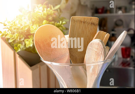 Close-up view of a group of wooden kitchen utensils inside a glass container. Cooking with traditional utensils Stock Photo