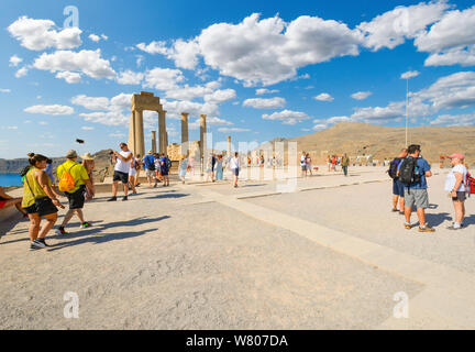 Tourists enjoy late afternoon views of the Mediterranean sea from the ancient ruins of the Lindos, Acropolis on the island of Rhodes, Greece Stock Photo