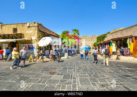 Tourists shop and sightsee near the city gate of the Mediterranean sea port city of Rhodes Greece on a summer afternoon. Stock Photo