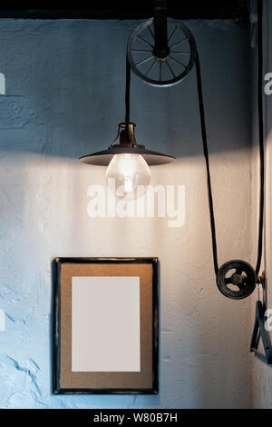 Style loft interior, Edisson lamp, photo wooden frame on the wall with empty place for an inscription. Stock Photo