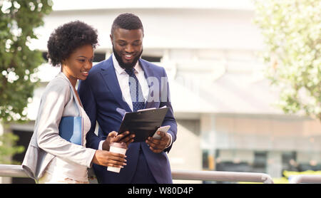 Two african american colleagues discussing new project outdoors Stock Photo