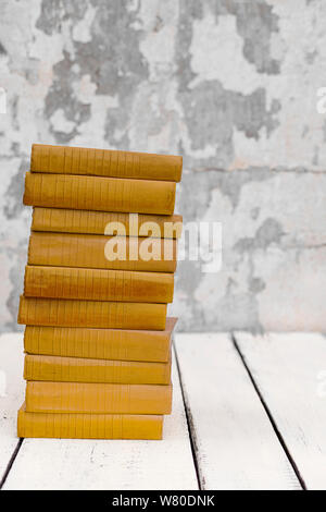 Stack of old ancient shabby books on a white wooden background. Selective focus. Stock Photo